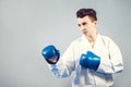 Girl in a white kimono and blue gloves is worth in combat drain, ready to attack, Royalty Free Stock Photo