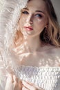 Girl in white light dress and curly hair with big feather near her face, portrait woman with feather, purity and innocence. Curly Royalty Free Stock Photo