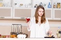 Girl in white men's shirt with a glass of red wine near the pans Royalty Free Stock Photo