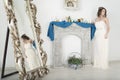 Girl in white near the mirror and the fireplace. Royalty Free Stock Photo