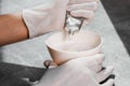 A girl in white protective gloves squeezes hair dye into an oxidizer. colorist at work close-up hair care hair mask hair