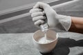 A girl in white protective gloves squeezes hair dye into an oxidizer. colorist at work close-up hair care hair mask hair