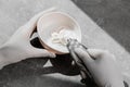 A girl in white protective gloves squeezes hair dye into an oxidizer. colorist at work close-up hair care hair mask hair
