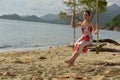 Girl in white with red flowers dress on the beach