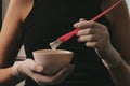 Girl in white rubber protective gloves holding a brush in her hands and stirring hair dye close-up colorist hair care at home hair