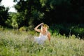 Girl in a white sundress and a wreath of flowers on her head sit Royalty Free Stock Photo