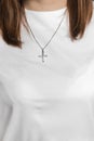 Girl in a white T-shirt with a cross ornament on a chain around her neck Royalty Free Stock Photo