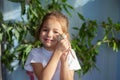 A girl in a white T-shirt holds a Mongolian gerbil on her hand. Baby and domestic mouse maintenance