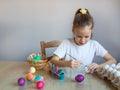 The child holds the painted eggs. Easter. A girl in a white T-shirt paints Easter colored eggs Royalty Free Stock Photo