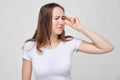 A girl in a white T-shirt is tormented by dizziness and disorientation