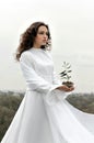 Girl who stands on a hill holding little sprout in her hands Royalty Free Stock Photo