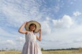 A girl who wearing a straw hat in a field in summer