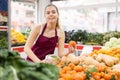 Girl salesperson in a store puts the tangerines on the counter