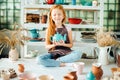 Girl wih many cups made from clay sitting in pottery studio Royalty Free Stock Photo