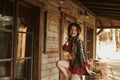 Girl in the Wild West, in Western house. Girl in hat with long cerly hair smile. Beautiful pretty girl in black hat. Incredible Royalty Free Stock Photo