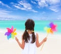 Girl with windmills on beach Royalty Free Stock Photo