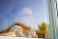 Girl in a window with garden refelctions