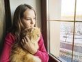 Girl window with a red cat home, fur, blonde