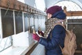 Girl in winter clothes on bell tower or belfry rings bells, hits iron plates with sticks. Church, christmas, music. Royalty Free Stock Photo