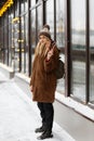 Girl in winter clothes and a hat holds two caramel candy canes Royalty Free Stock Photo