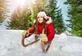 Girl in winter clothes having fun on snow sledge