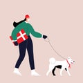 A girl in winter clothes and a medical mask on her face with a gift in her hands walks with a dog with a scarf around Royalty Free Stock Photo