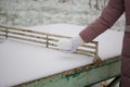 Girl in winter clothes for a walk. He holds a snowball in his hands. Standing near a concrete tennis table. Everything is covered Royalty Free Stock Photo