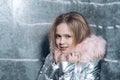 Girl in winter coat with fur hood, fashion. Little child with long blond hair, hairstyle and beauty. Kid fashion trend