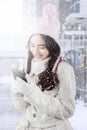 Girl in winter coat sending message with cellphone Royalty Free Stock Photo
