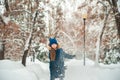 Girl in the winter forest close-up and copy space. A child plays in the winter with snow Royalty Free Stock Photo