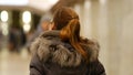 Girl in winter jacket looks at camera then turns sharply and walks away