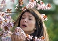 Girl wiping nose in front of blooming tree in spring Royalty Free Stock Photo