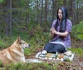 Girl witch conjures in the woods. Near a huge dog Royalty Free Stock Photo