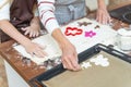 Girl and woman in aprons cutting out biscuit shapes Royalty Free Stock Photo