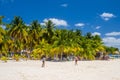 Girl woman and boy are playing with a ball on a white sand beach with cocos palms, Isla Mujeres island, Caribbean Sea, Cancun, Royalty Free Stock Photo