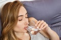 Girl woman drink water in bed at home, healthcare concept, hangover Royalty Free Stock Photo