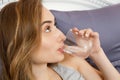 Girl woman drink water in bed at home, healthcare concept, hangover Royalty Free Stock Photo