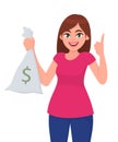 Girl, woman, or female holding/showing cash, money, currency note bag with dollar sign and pointing up index finger. Modern. Royalty Free Stock Photo