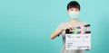 Girl or woman wear face mask and hand`s holding black clapper board or movie slate use in video production ,film, cinema industry Royalty Free Stock Photo