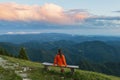 Girl on the wooden bench high in the mountains enjoy sunset