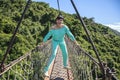 Girl on a wooden bridge across a mountain in the park of Yalong Bay Tropic Paradise Forest Royalty Free Stock Photo