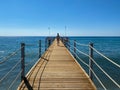 A girl on a wooden long pontoon, a pier with rope railings on the sea on the beach on vacation in a heavenly warm eastern tropical Royalty Free Stock Photo