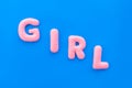 Girl word as decoration for baby shower on blue background top view
