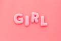 Girl word as decoration for baby shower on pink background top view