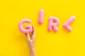 Girl word as decoration for baby shower on yellow background top view