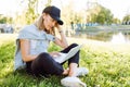 Girl working at the computer sittingon the grass in a protective medical mask on her face. Freelance, quarantine concept