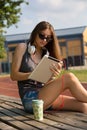 The Art of Multitasking: Girl Embracing Education and Music in the Park