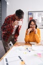 Girl working with her colleague while eating sandwich