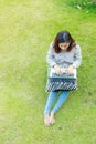 Girl working on her laptop computer outside on green lawn Royalty Free Stock Photo