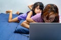 A girl working from home on her bed with laptop and headset being bothered by kids. Mommy working from home during stay home Royalty Free Stock Photo